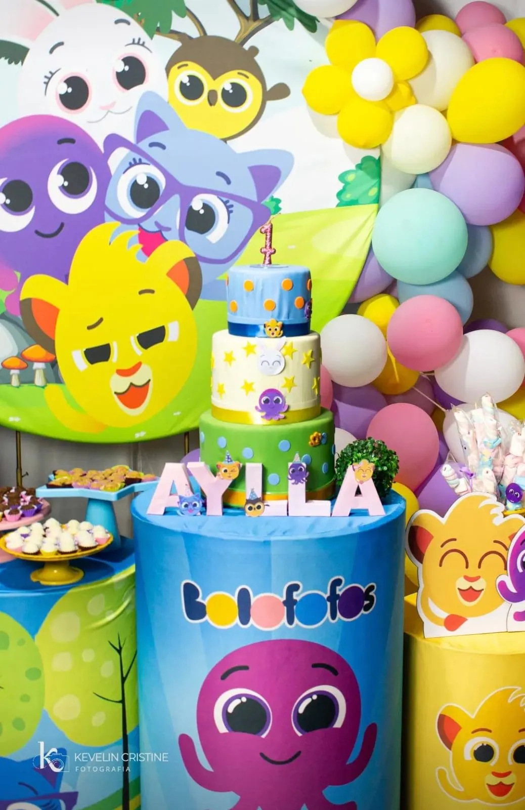 Mesa de aniversário com personagens Bolofofos, balões coloridos e o bolo da Aylla