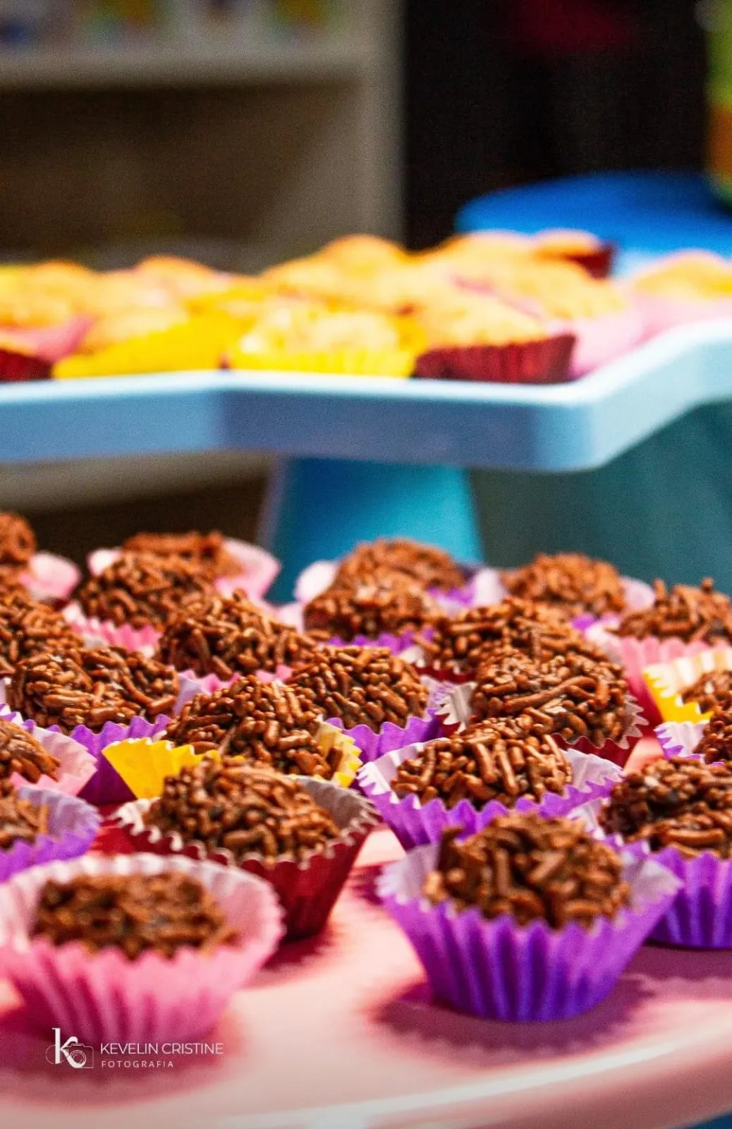 Brigadeiros em forminhas lilás na mesa de doces da festa