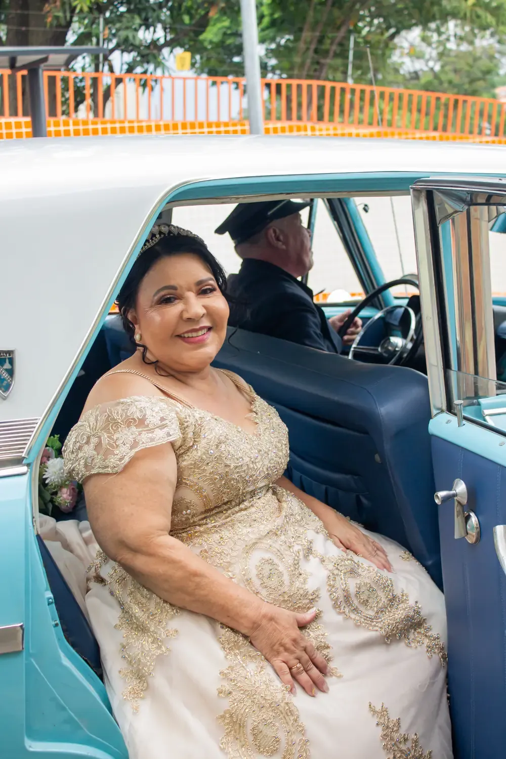 Noiva sorridente dentro de um carro antigo azul, a caminho da cerimônia