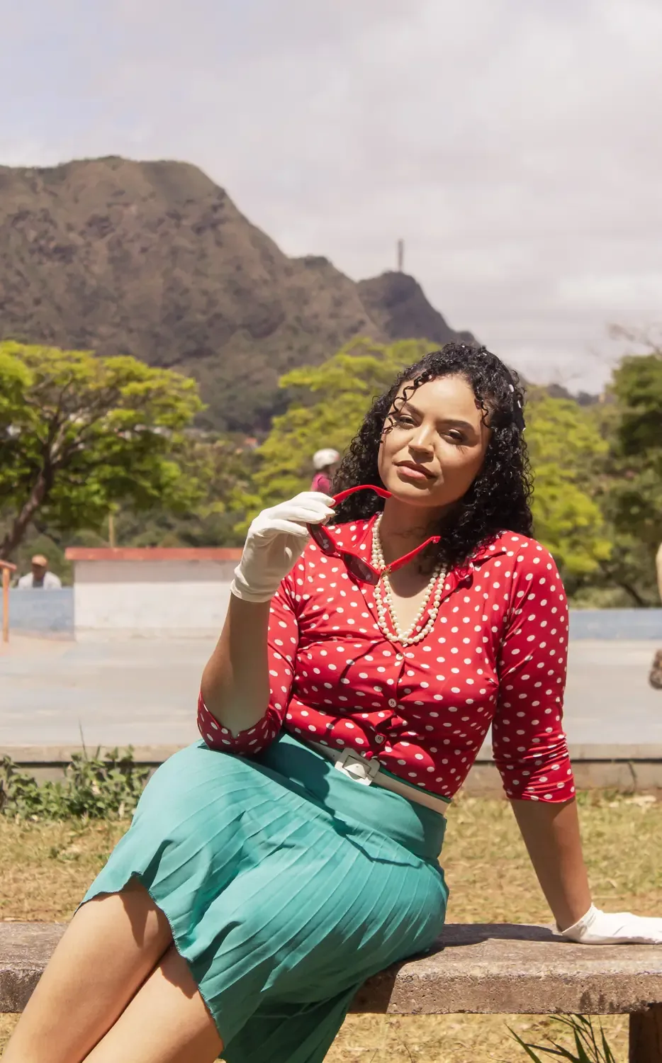 Retrato sentada em um banco, com as montanhas ao fundo