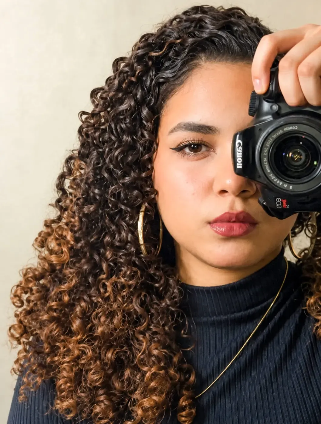 Kevelin, fotógrafa, com a câmera diante do rosto
